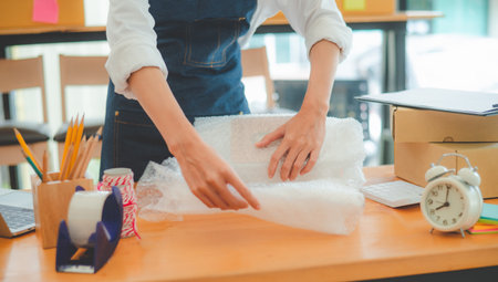 Online small business owners are packing their ordered products into the boxes for their customers based on the concept of online shopping - online shopping.の写真素材