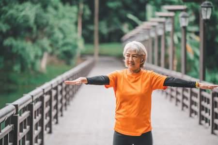 Elderly woman exercising in the park early in the morning.の写真素材