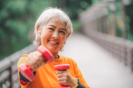 Elderly, white-haired woman exercising in the park early in the morning.の写真素材