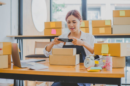 Small business owners online are taking pictures of their products and offering them to customers who will place their orders. and check the orders that the customers have ordered of online retailers - online shoppingの写真素材