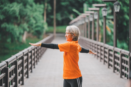 Elderly, white-haired woman exercising in the park early in the morning.