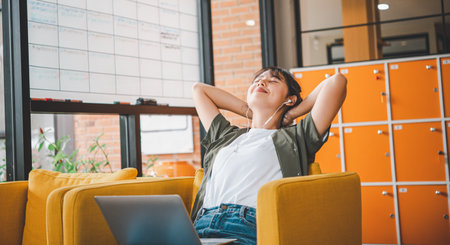 Young freelancers are stretching and relaxing after working on a laptop in a cafe.