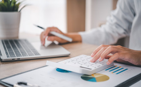 close up The business person is sitting on a calculator with a graph in the office of finance accounting conceptの写真素材