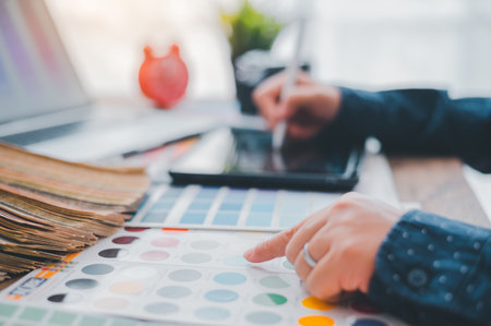 Graphic designer architects who work with laptops and color comparison tables for design work.の写真素材