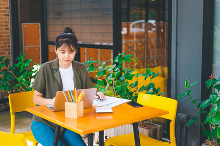 Freelance worker working on documents with graphs. and information about finances on laptops in...