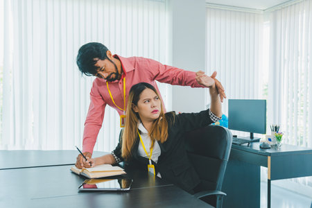 Boss or supervisor touching female employee's shoulder Causing young employees to resist because they are uncomfortable and afraid of being sexually abused. Concept of sexual harassment in the workplaceの写真素材