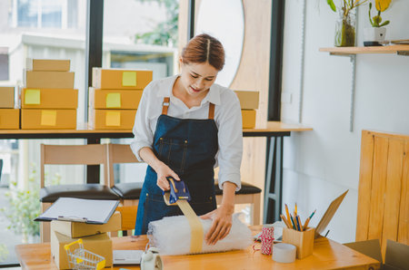 Online small business owners are packing their ordered products into the boxes for their customers based on the concept of online shopping - online shopping.の写真素材