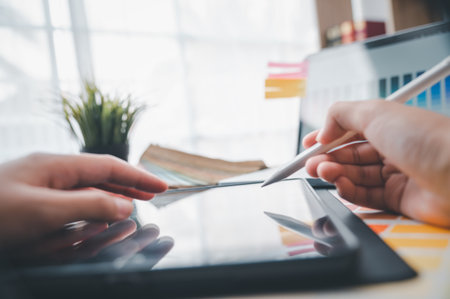 Graphic designer architects who work with laptops and color comparison tables for design work.の写真素材