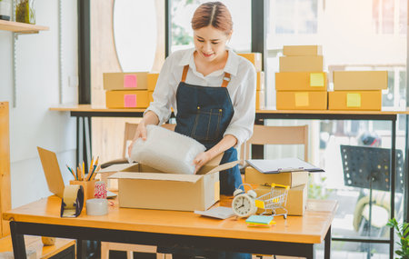 Online small business owners are packing their ordered products into the boxes for their customers based on the concept of online shopping - online shopping.の写真素材