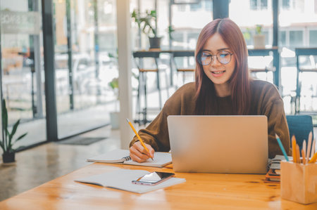 young student wearing headphones studies online, distance learning, and keeps up to date on the...