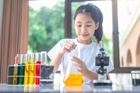 little scientist looking through a microscope and test tubes filled with chemicals for learning...