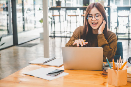 young student wearing headphones studies online, distance learning, and keeps up to date on the global coronavirus pandemic.の写真素材
