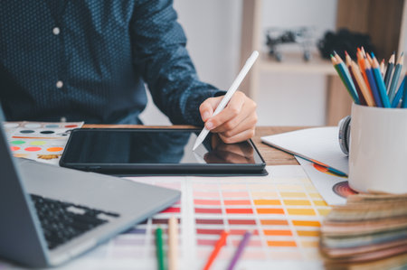 Graphic designer architects who work with laptops and color comparison tables for design work.の写真素材