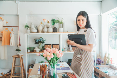 Small business owners are preparing a small shop and checking through a tablet and checking orders.