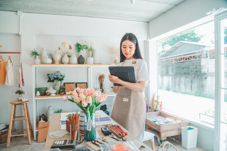 Small business owners are preparing a small shop and checking through a tablet and checking orders.の写真素材