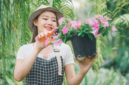 Young women doing hobbies taking care of plants, watering, shoveling flowers. In the garden during the break from workの写真素材