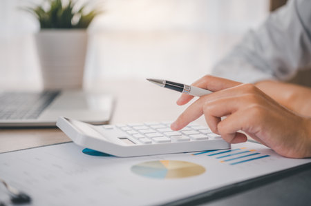close up The business person is sitting on a calculator with a graph in the office of finance accounting conceptの写真素材