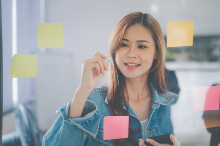 Web designers creating planning and analyzing with Colorful sticky notes on the office board.web design conceptの写真素材
