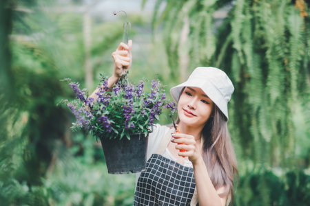 Young women doing hobbies taking care of plants, watering, shoveling flowers. In the garden during the break from workの写真素材
