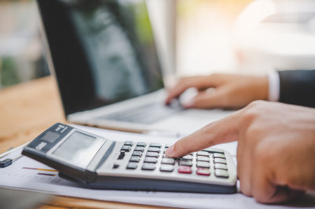 business person sitting at a desk at an office By using the calculator to work. Business Concept Analysis and Planningの写真素材