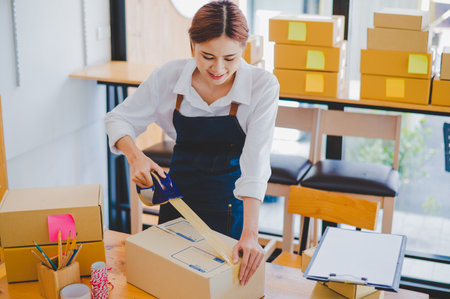 Online small business owners are packing their ordered products into the boxes for their customers based on the concept of online shopping - online shopping.の写真素材
