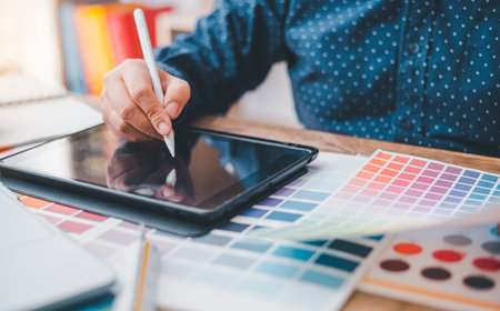 Graphic designer architects who work with laptops and color comparison tables for design work.の写真素材