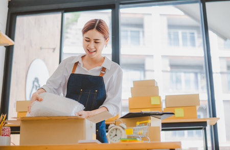 Online small business owners are packing their ordered products into the boxes for their customers based on the concept of online shopping - online shopping.の写真素材