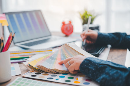 Graphic designer architects who work with laptops and color comparison tables for design work.の写真素材