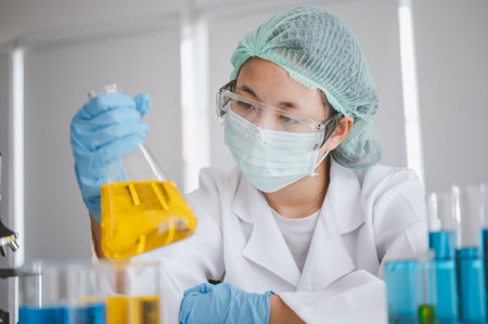 Female researchers are experimenting with pipette dropping a sample into a test tube in an experiment research in laboratory..の写真素材