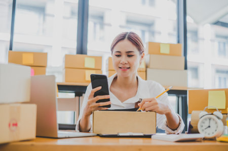 Small business owners online are writing their names and addresses to deliver products and products to their customers. and check the orders that the customers have ordered of online retailers - online shoppingの写真素材