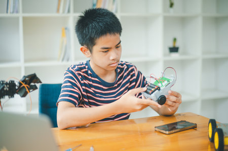 Asian boy learning and studying the work of technology robots.homeschool and science for tech project. playing childhood kids hobby leisure lifestyle people toys robotics technology.の写真素材