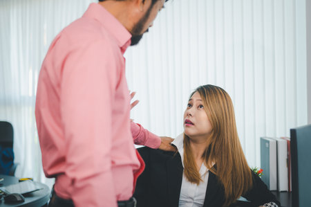 Boss or supervisor touching female employee's shoulder Causing young employees to resist because they are uncomfortable and afraid of being sexually abused. Concept of sexual harassment in the workplaceの写真素材