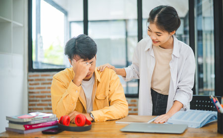 Fellow students are consoling friends who are disappointed in grades, frustrated with tasks that are not meeting their goals, helping each other.の写真素材
