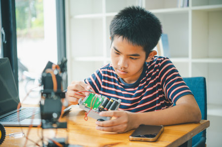 Asian boy learning and studying the work of technology robots.homeschool and science for tech...