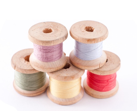 different types colored bobbin threads on white 