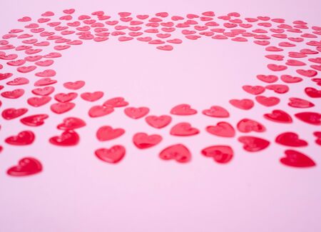 Little red hearts shape big one on pink backgroundの写真素材