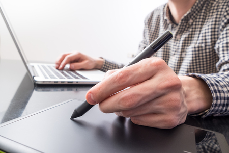 Designer using pen and tablet for drawingの写真素材