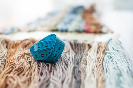 Close up set of colorful wool threads and measuring tape. Abstract hobby background