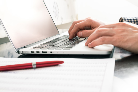 Man in office reviewing report with laptop