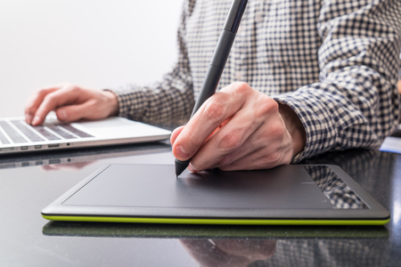 Designer using pen and tablet for drawingの写真素材