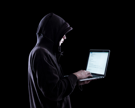 Anonymous hacker with laptop in the dark. Cyber security concept