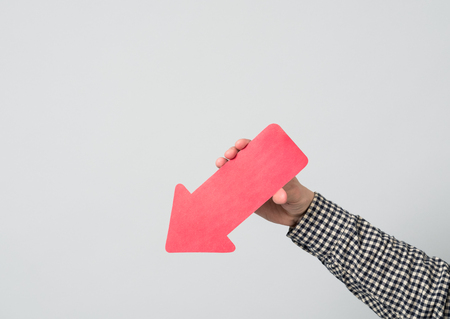 Hand holding and pointing red arrow downの写真素材