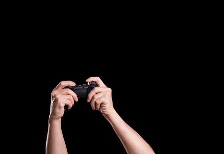 Hands of male holding gamepad in the dark