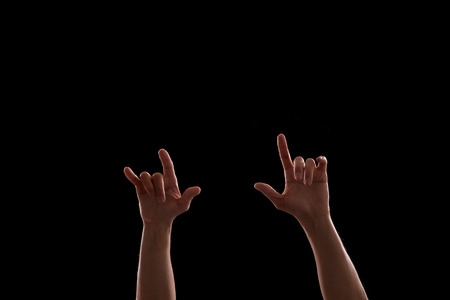 Raised hands in the dark on rock music concert
