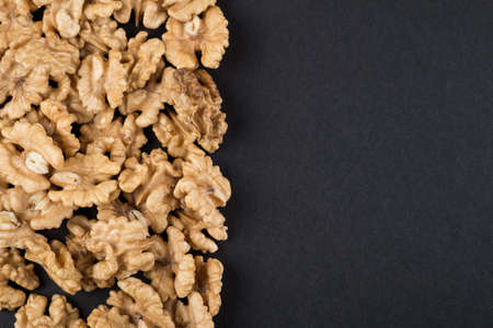 Walnut kernels isolated on black with copy space. Raw food ingredients view from aboveの写真素材