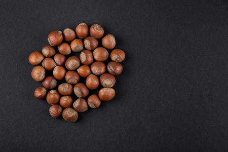 Hazelnuts in shell isolated on black. Raw food ingredients top viewの写真素材
