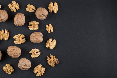 Walnut in shell and kernels isolated on black. Raw food ingredients top view