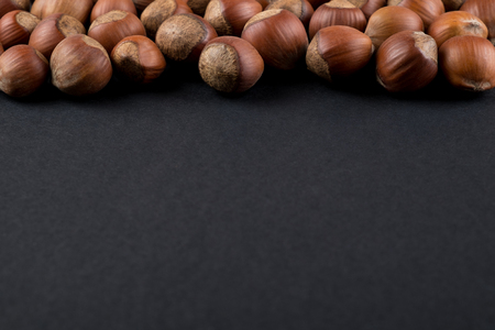 Hazelnuts in shell isolated on black with copy space. Raw food ingredients top viewの写真素材