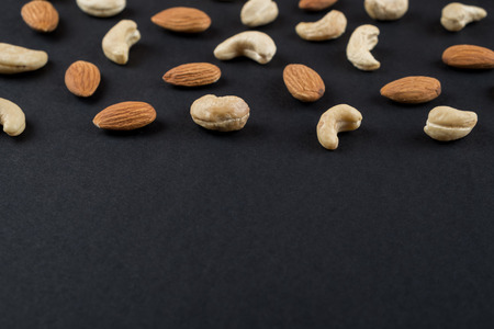 Cashew and almonds kernels isolated on black. Raw food ingredients