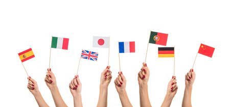 National flags of Germany, England, Italia, Japan, China Spain, France, Portugal in hands. Language studying concept on white backgroundの写真素材